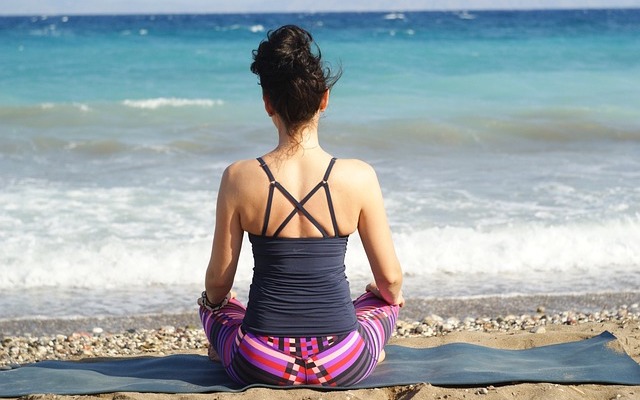 Woman meditating on the beach