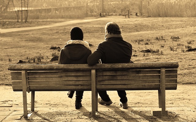 Couple sitting close together, talking supportively